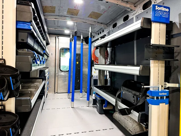 The Revolution Upfitting team installing a Sortimo shelving system in a work van