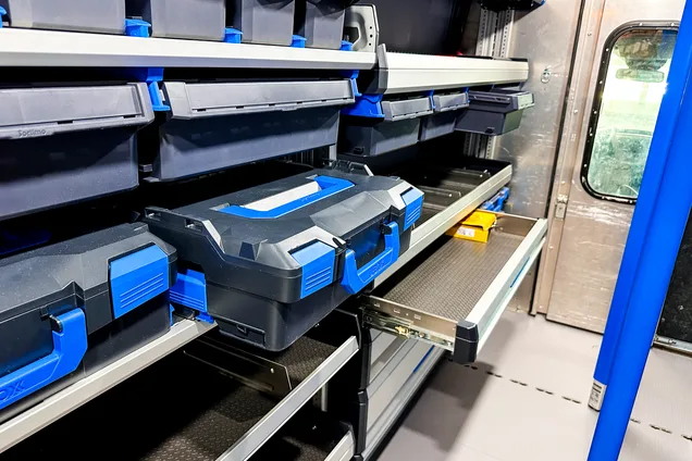 Upfitted cargo van interior with shelving and organized bins