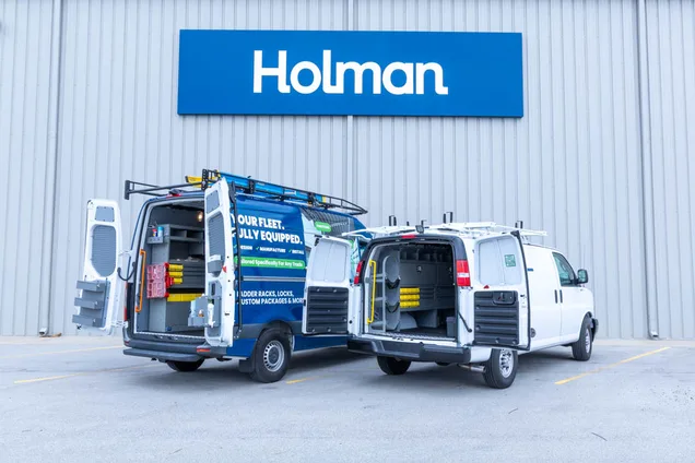 Two matching upfitted work vans from a standardized fleet program