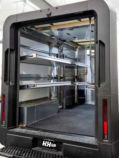 Box truck rear opening with shelving and drawer units along the left wall