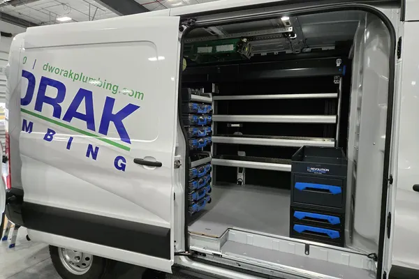 Dworak Plumbing van with the side door open, showing Sortimo shelving, parts cases, and a drawer unit