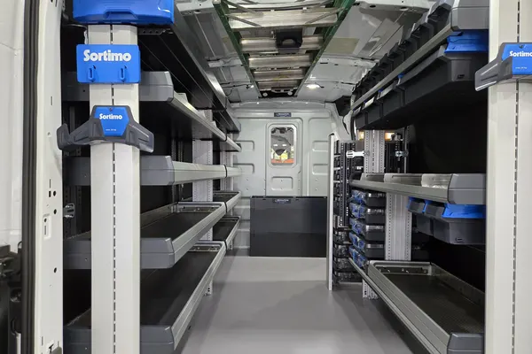 View down the center aisle of the Dworak Plumbing van between Sortimo shelving on both walls
