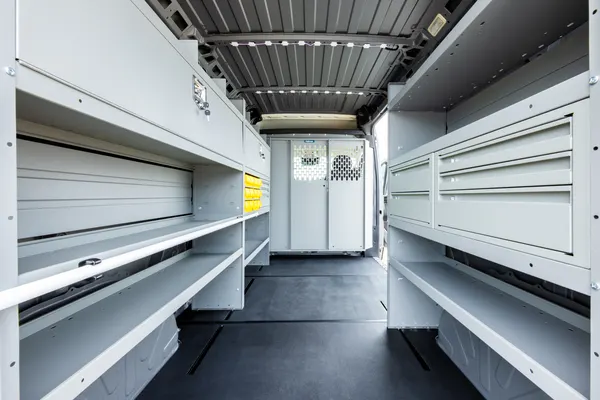 Holman shelving lining both walls of a high-roof van, seen from the rear doors