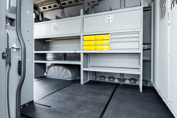 Holman gray shelving with yellow parts bins and a drawer cabinet on a van wall