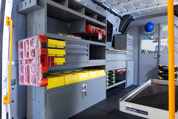 Holman shelving with yellow bins, parts cases, and a slide-out tray in a Mercedes Sprinter