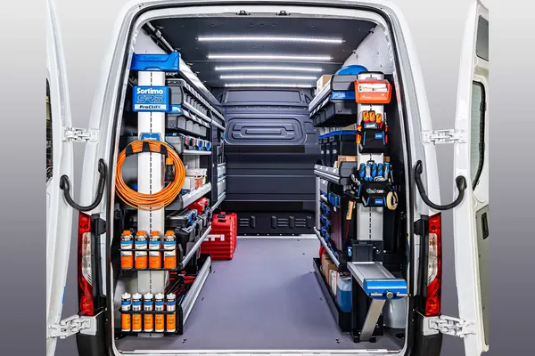 Sortimo shelving in a van with orange cord reels and supplies hung on the rear door