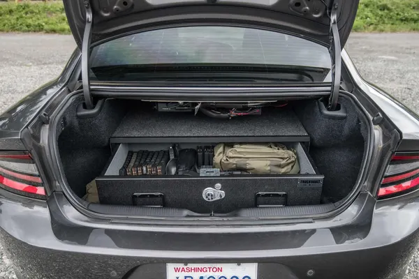 Single-drawer TruckVault open in the trunk of a Dodge Charger, holding field gear