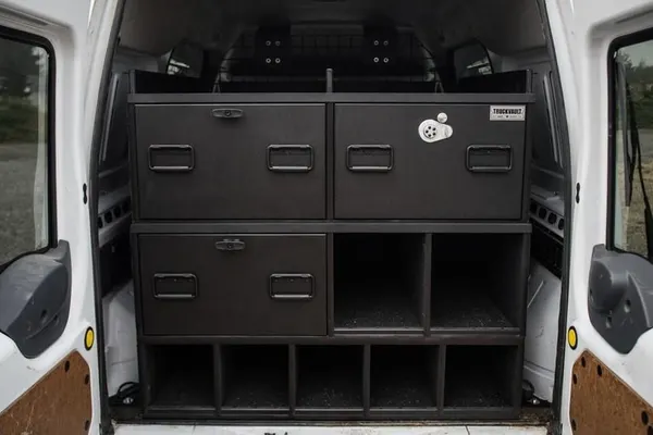 Stacked TruckVault drawers and cubbies filling the rear cargo area of a small work van
