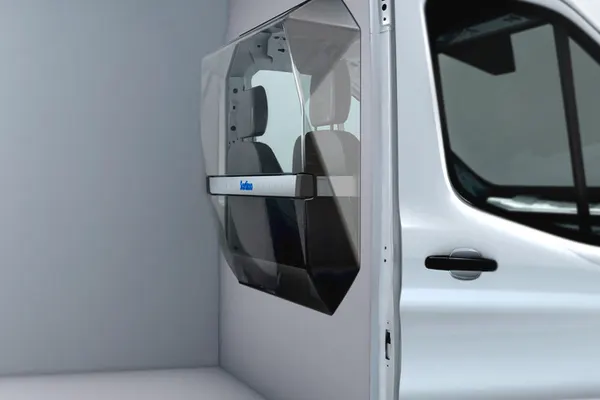 Sortimo ProPartition light bulkhead with a clear window installed behind the seats of a Ford Transit