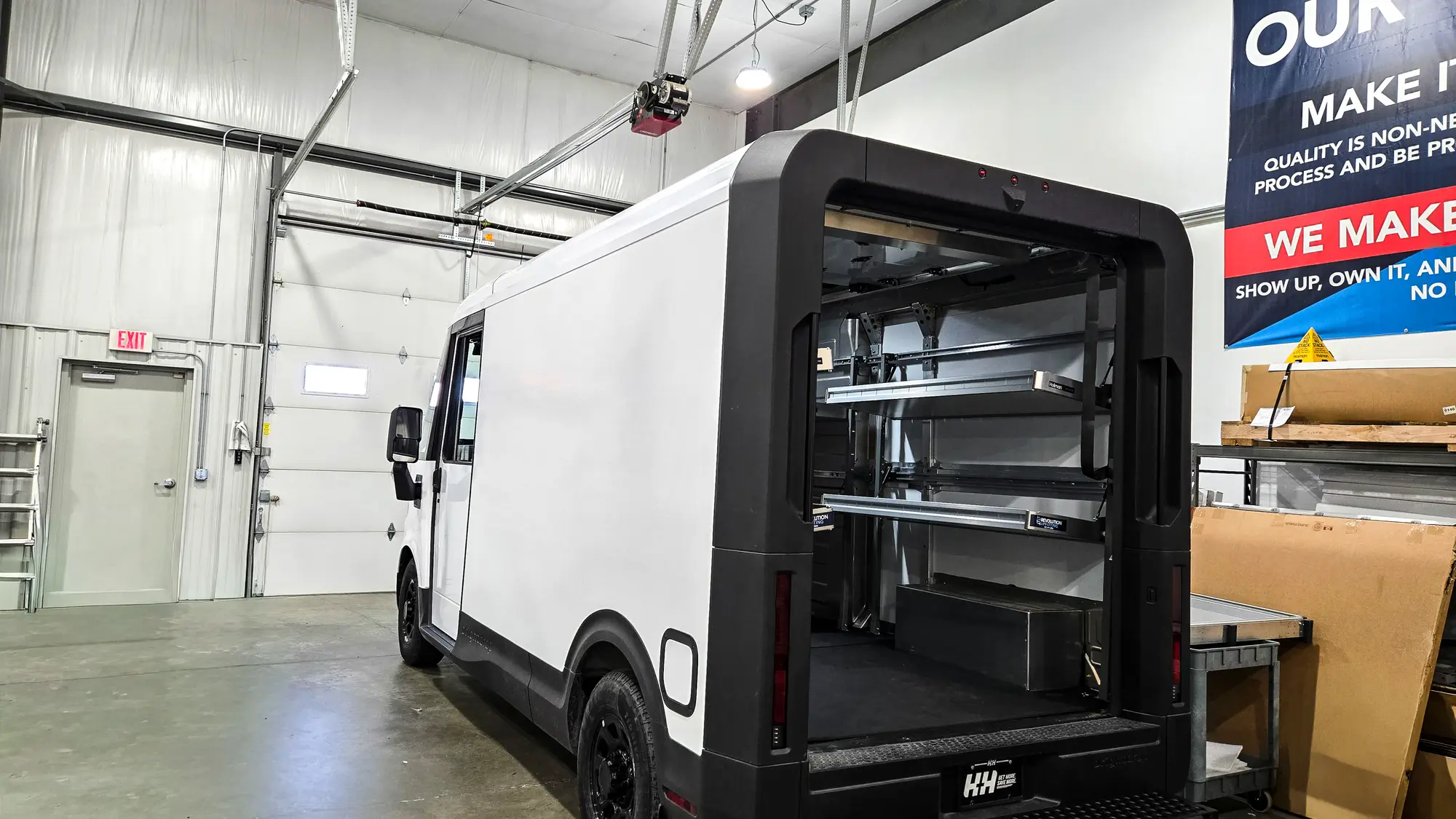 Walk-in box truck with a shelving upfit, parked inside a shop