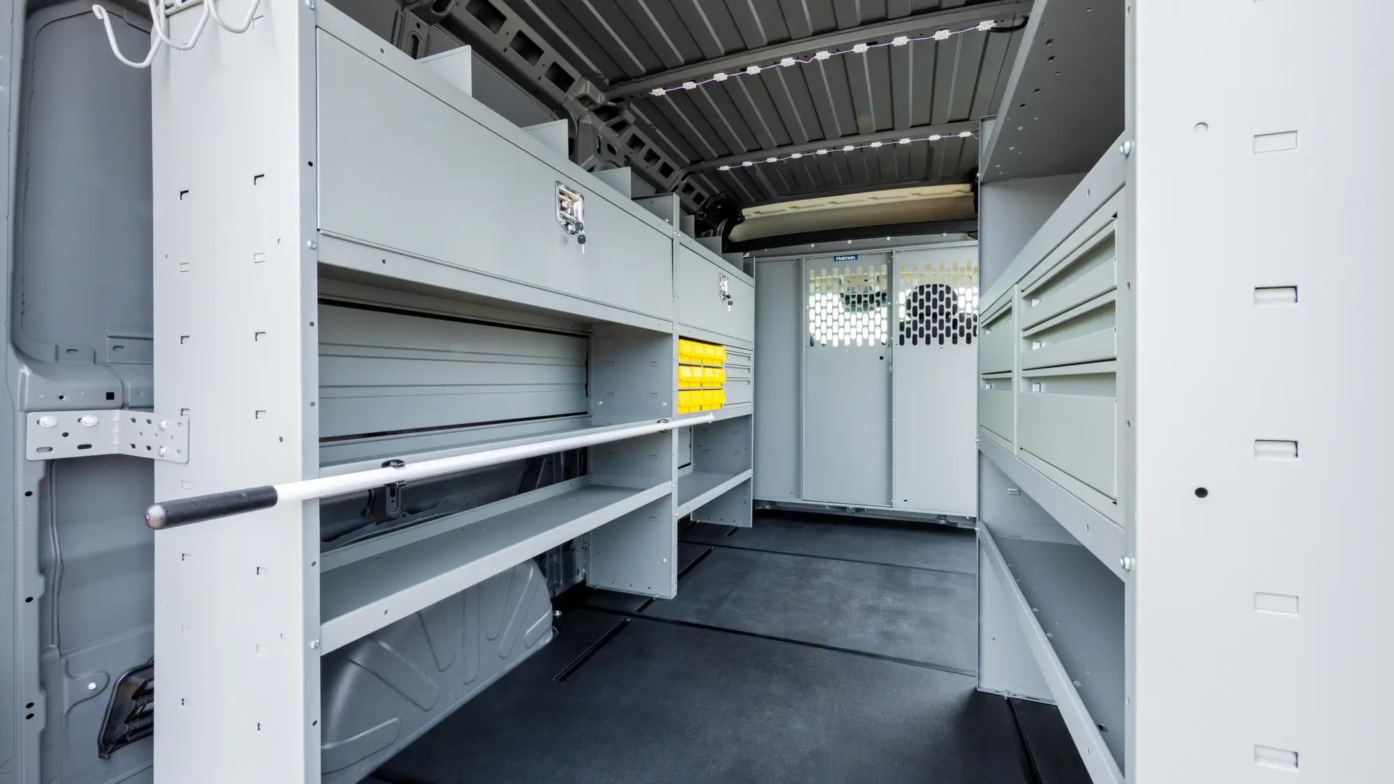 Holman rigid cargo flooring running the length of a shelved work van