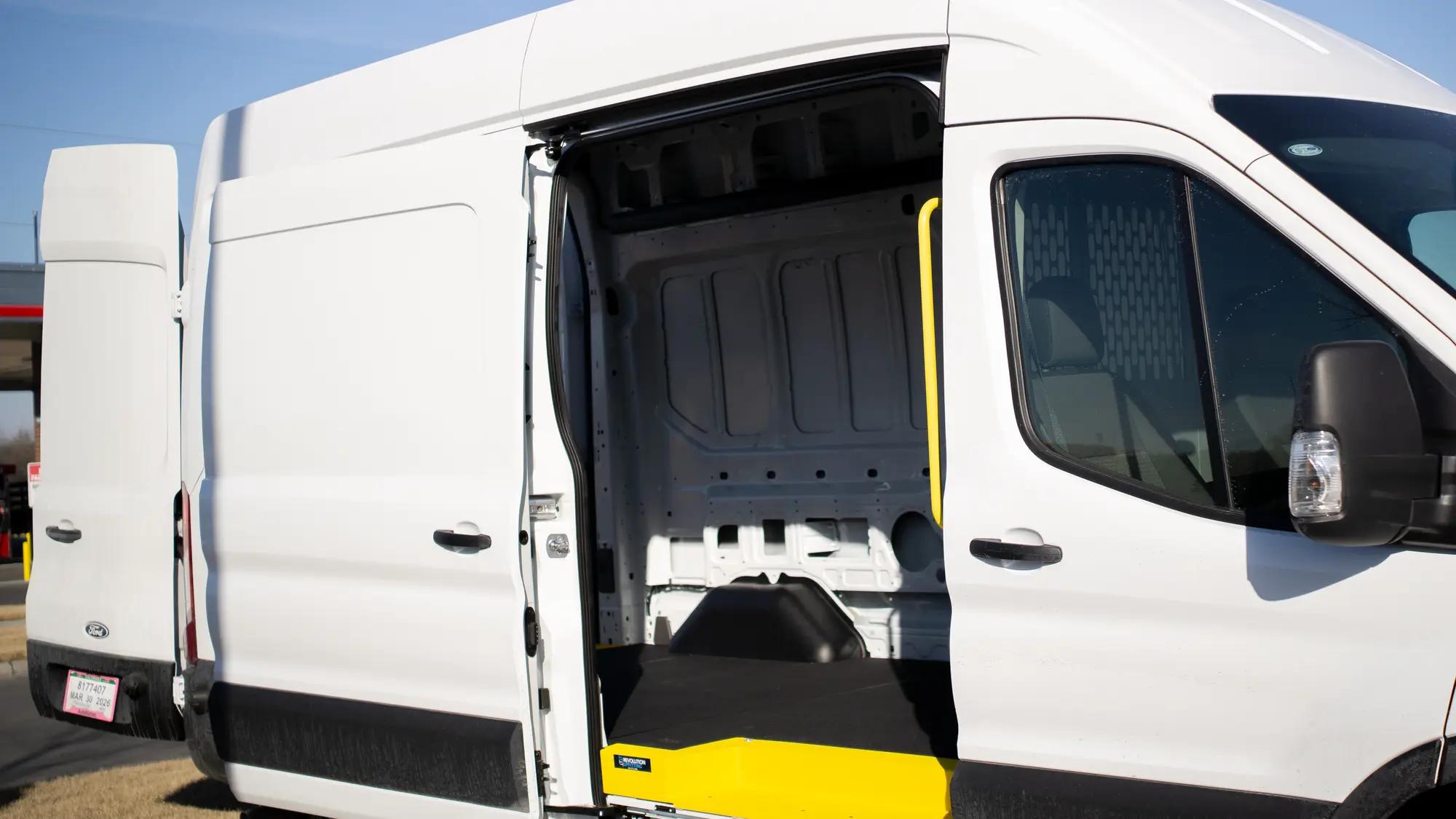 White work van with its sliding side door open to the cargo area