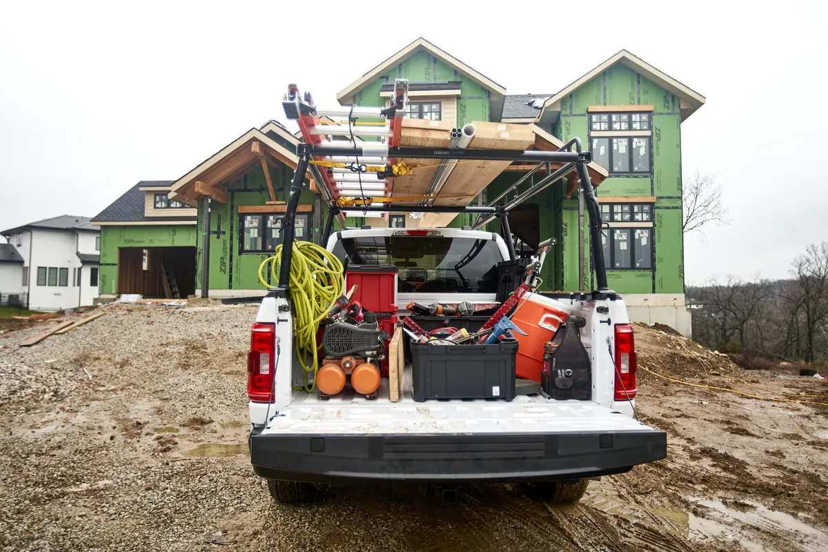 Pickup truck bed loaded with toolboxes and equipment on a jobsite