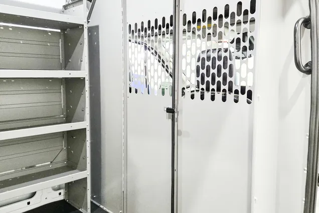 Cargo van interior with a perforated safety partition behind the cab