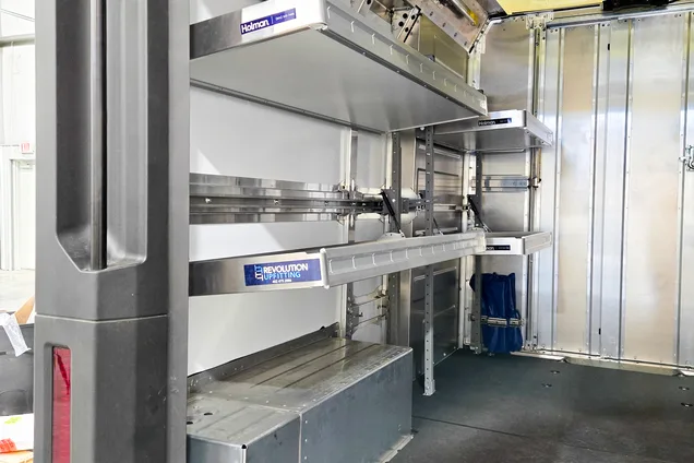Installer fitting shelving components inside a work van